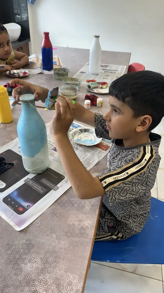 A guest painting florals onto a glass bottle for the first time