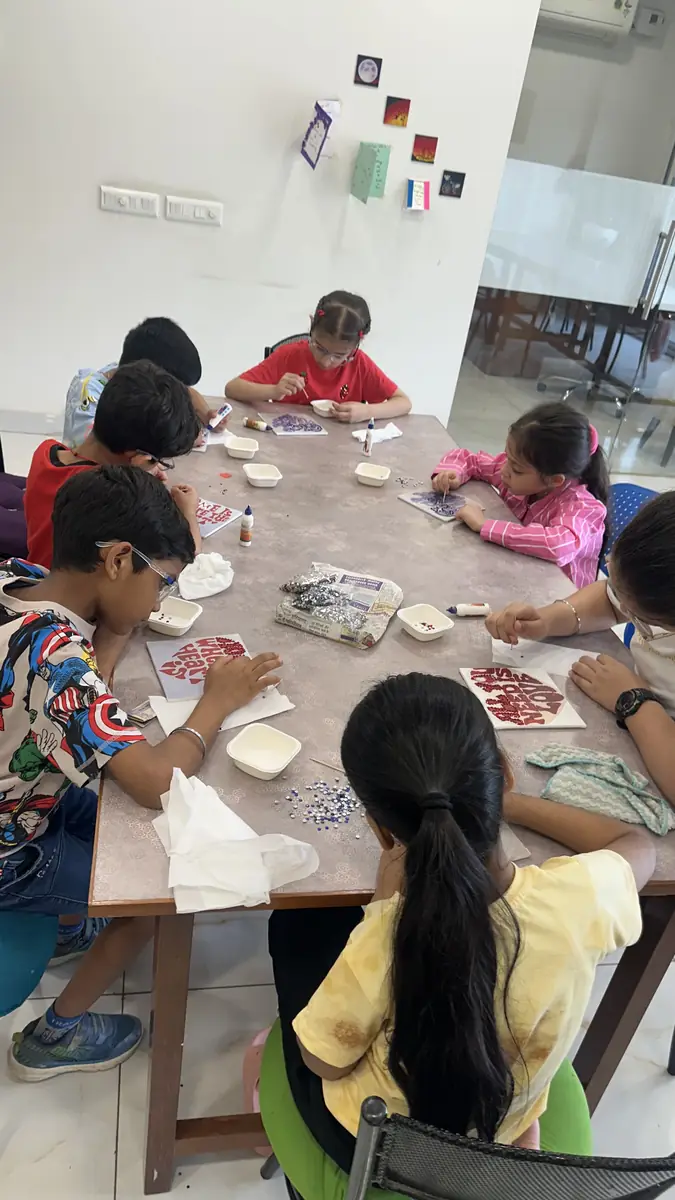 Children painting together at their own table in the studio